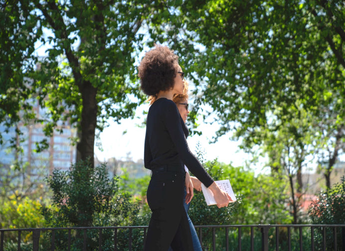 two ladies walking in a park